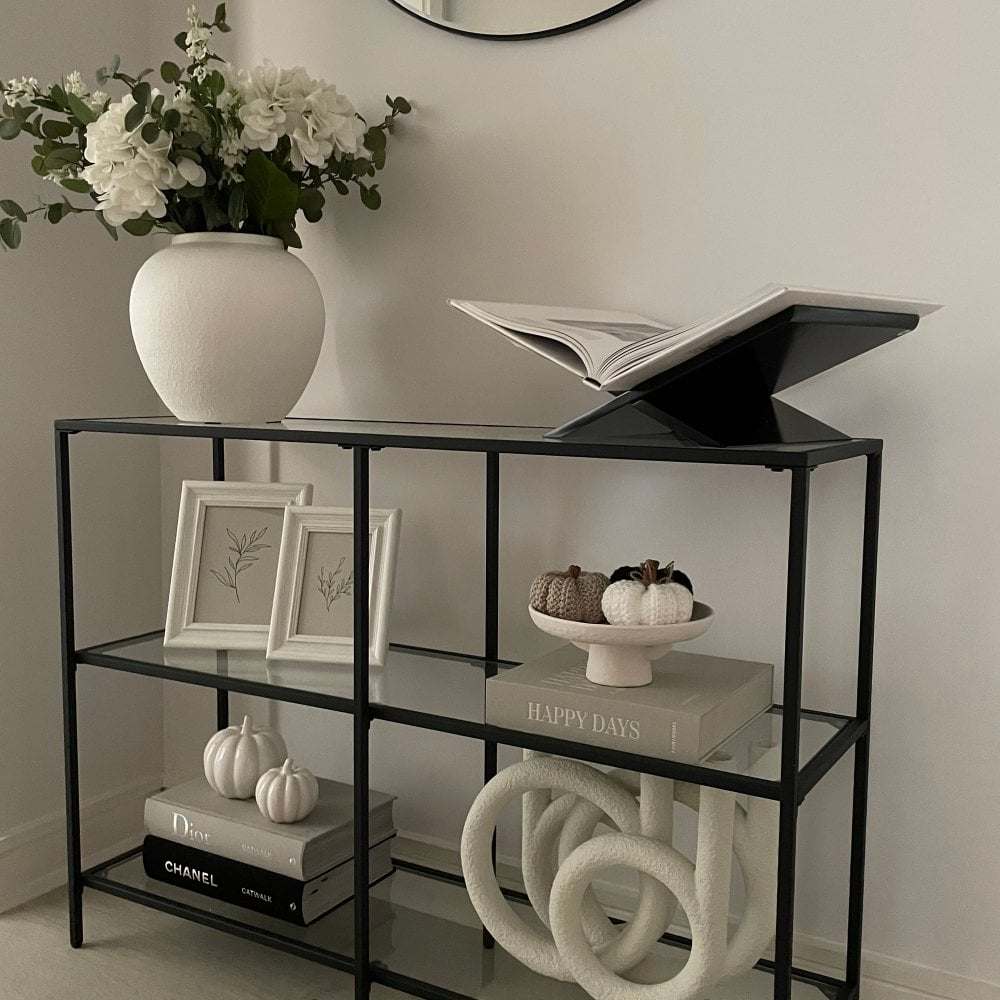 Contemporary black console table with three spacious tiers, ideal for displaying décor, books, or essentials.
