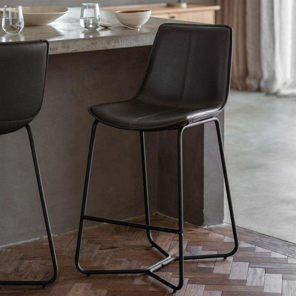 Set of two industrial-style bar stools in charcoal faux leather, offering a sleek and comfortable seating option.
