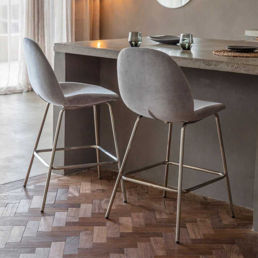 Chic and comfortable set of two light grey velvet bar stools, designed to enhance any modern dining or bar space.
