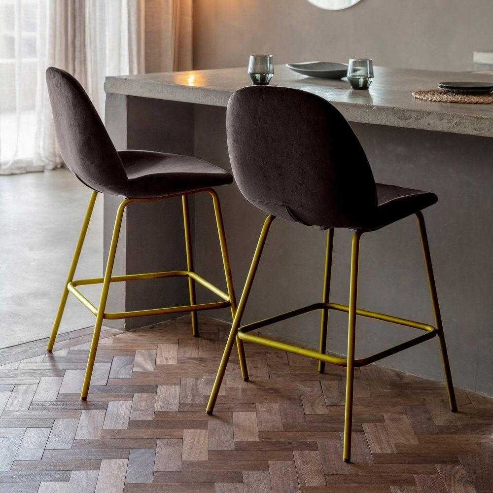 Stylish pair of modern deep brown velvet bar stools, perfect for adding luxury and comfort to any bar or kitchen space.
