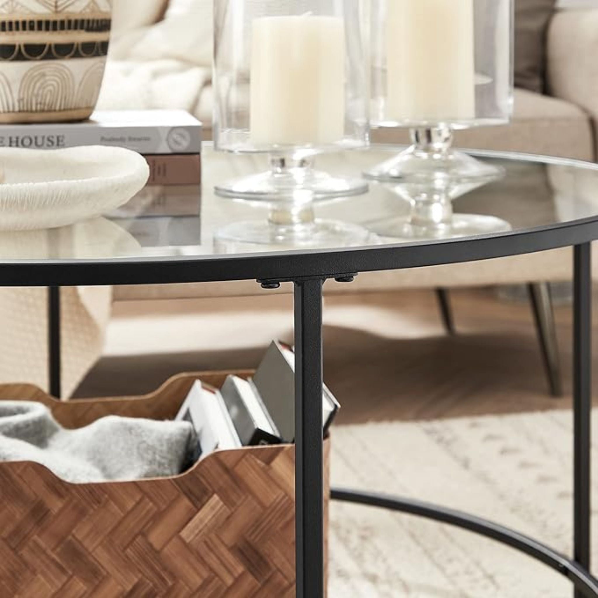 Modern round coffee table with a black glass top, designed for elegant and functional living room décor.

